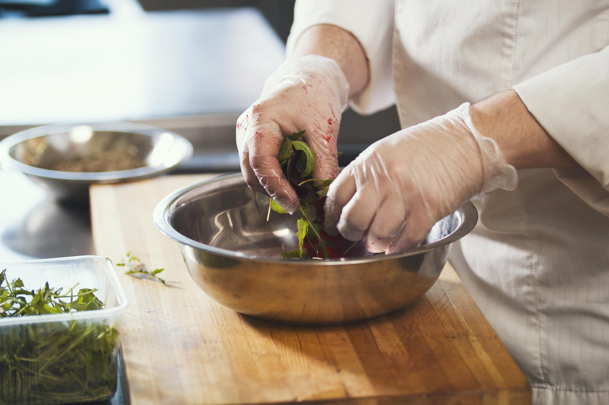 Chef arranging plated dish with herbs